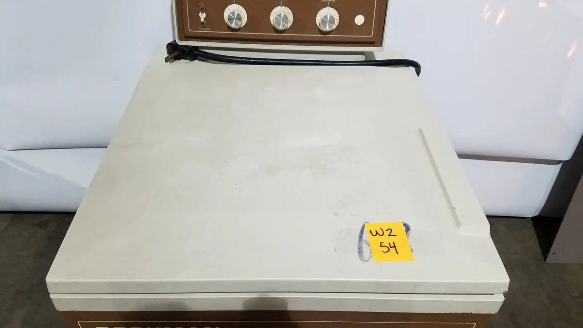 Cream-colored beckman j2-21 refrigerated centriifuge with brown control panel, three dials, and black power cord