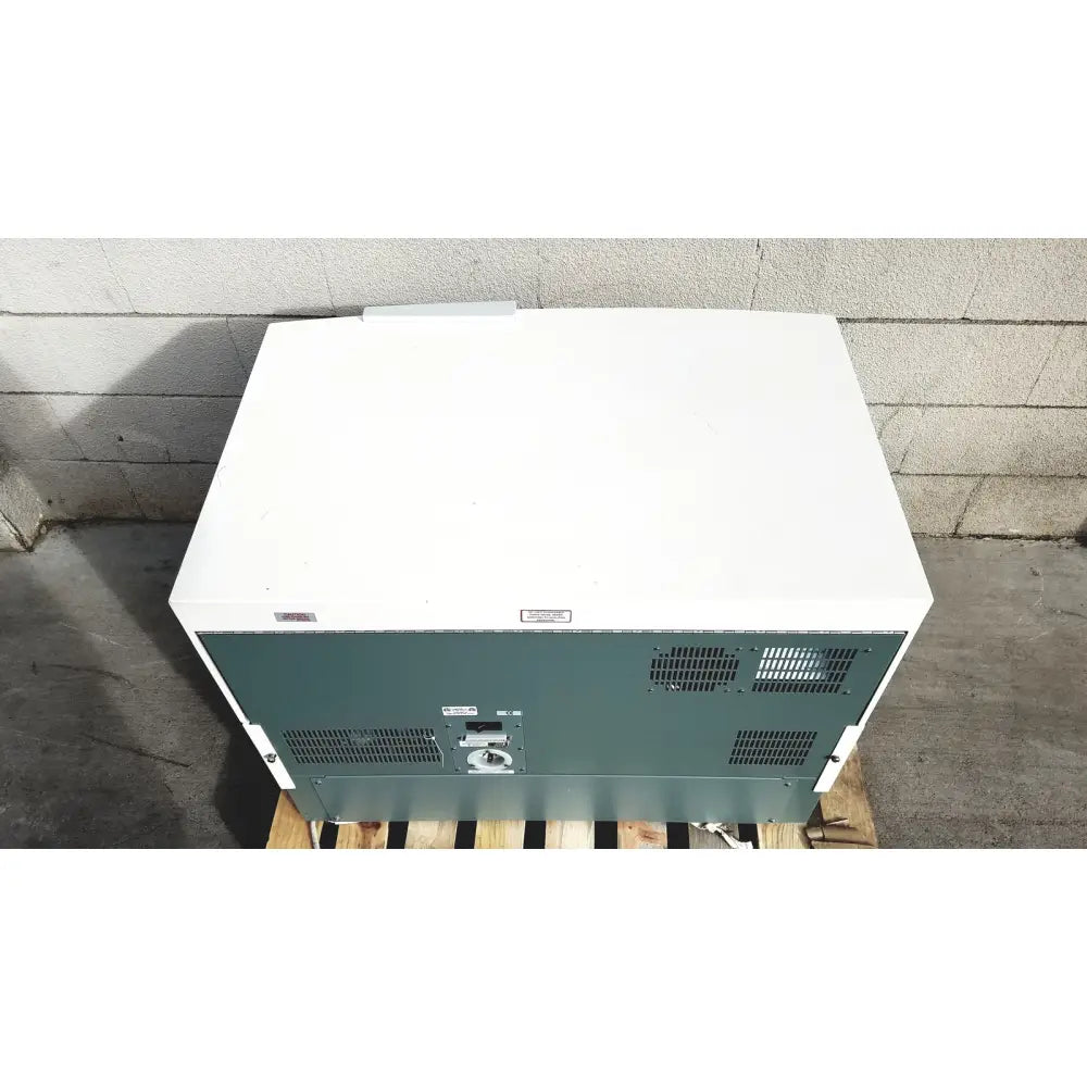 White and green industrial freezer with ventilation grilles on back panel of becton dickinson facscalibur flow cytometer