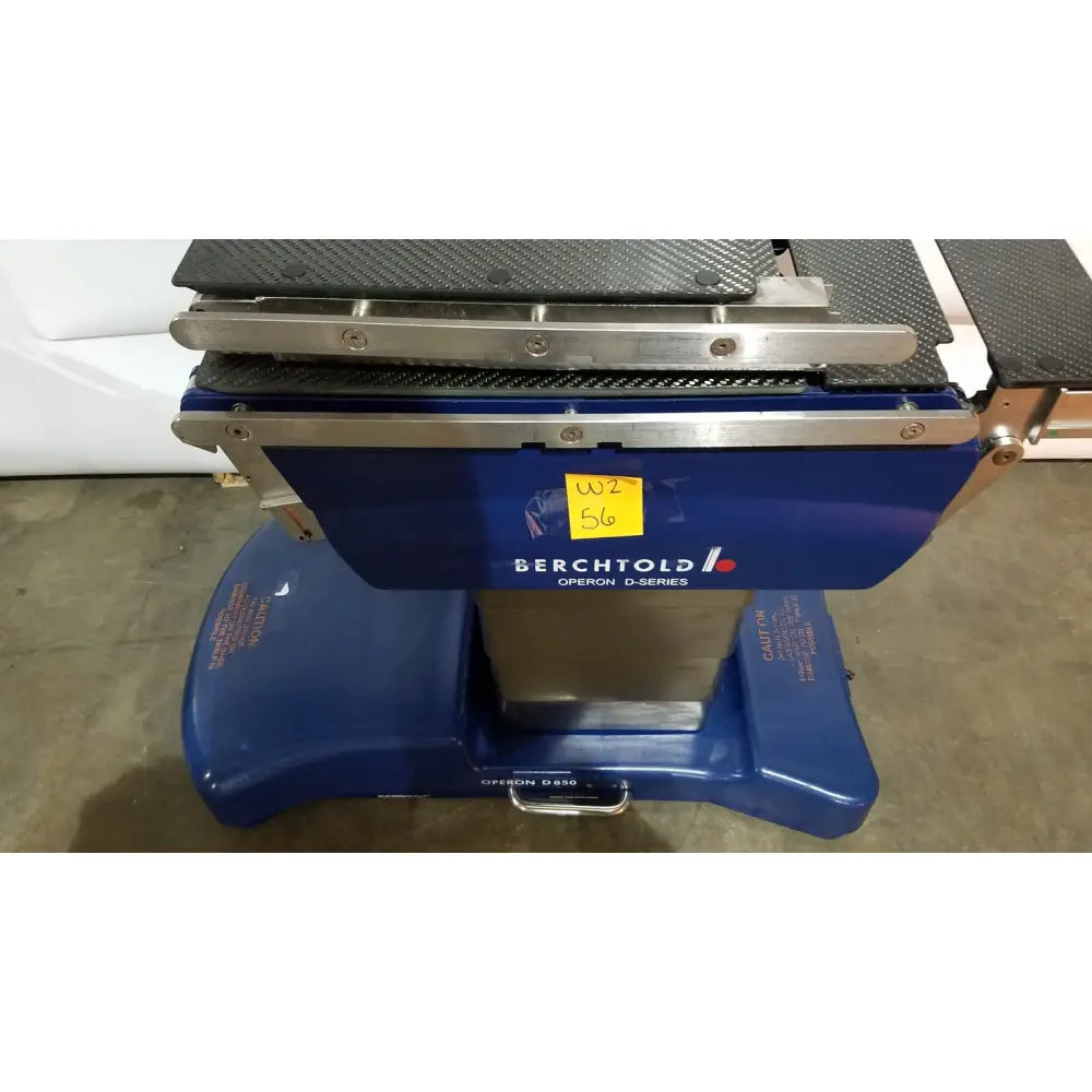 Berchtold d850 operon surgical table with blue d-series dental operatory featuring carbon fiber textured top and stainless steel frame