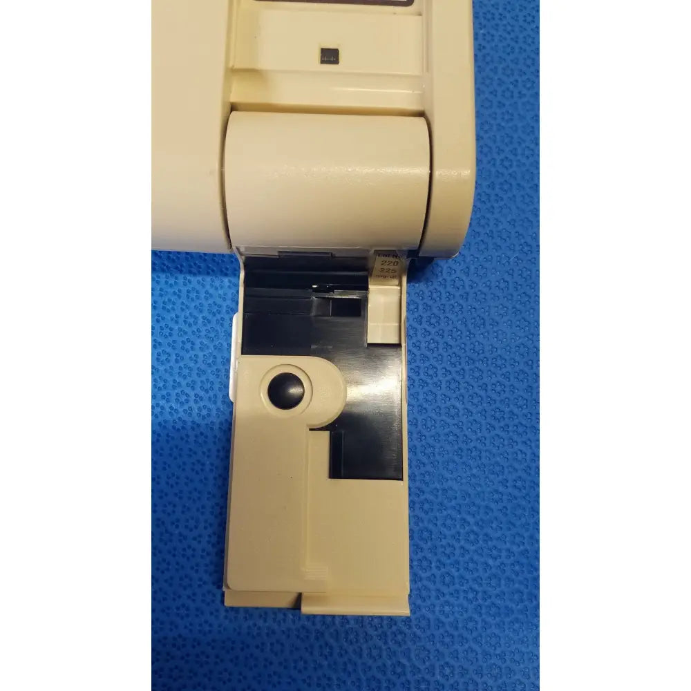 Beige plastic Bio-Dynamics Accu-Chek blood glucose monitor with black ink cartridge slot and small circular opening