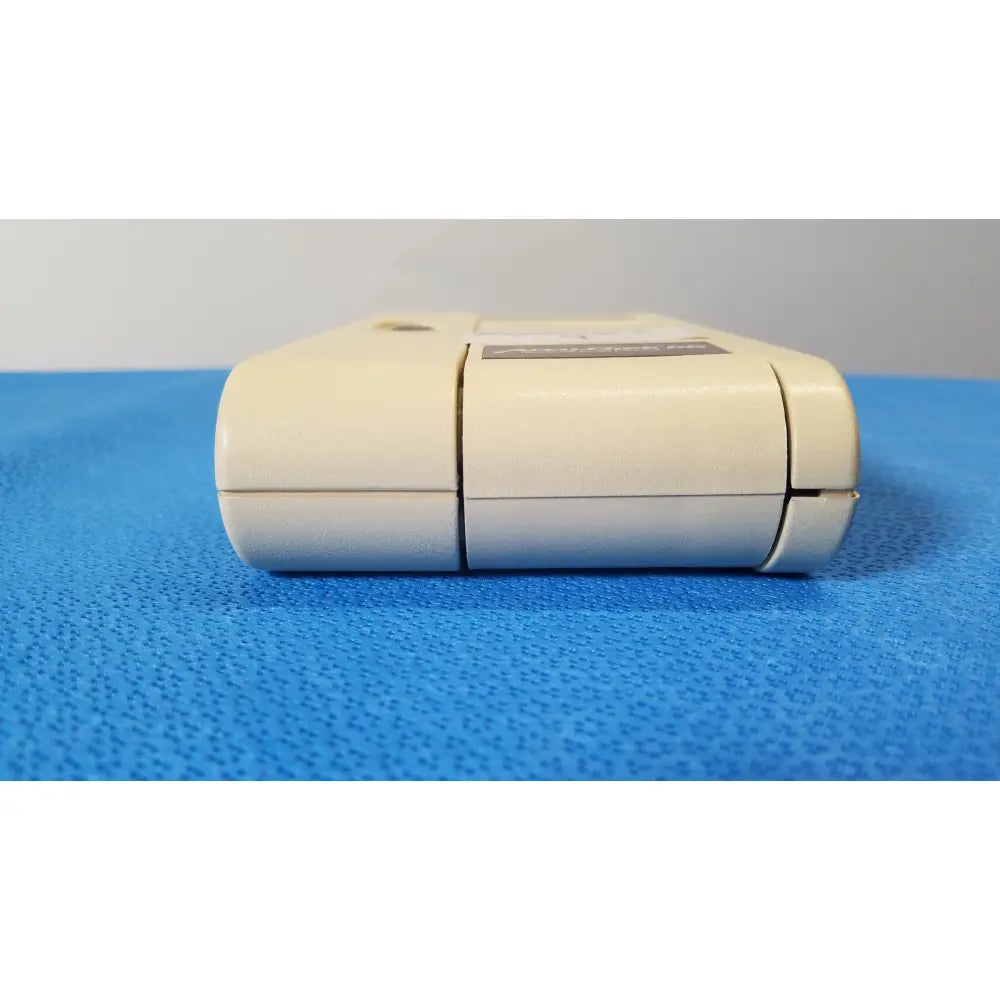 Cream-colored plastic super nintendo entertainment system game cartridge with black label and seam lines for glucose monitor use