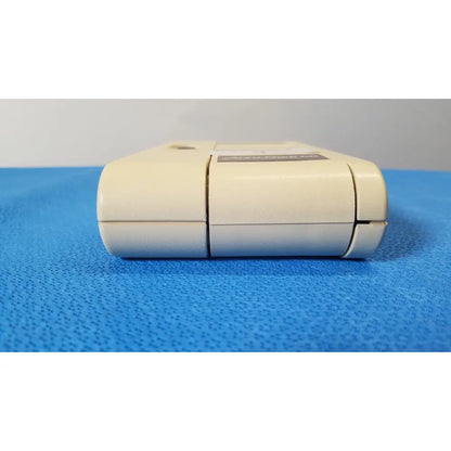 Cream-colored plastic super nintendo entertainment system game cartridge with black label and seam lines for glucose monitor use