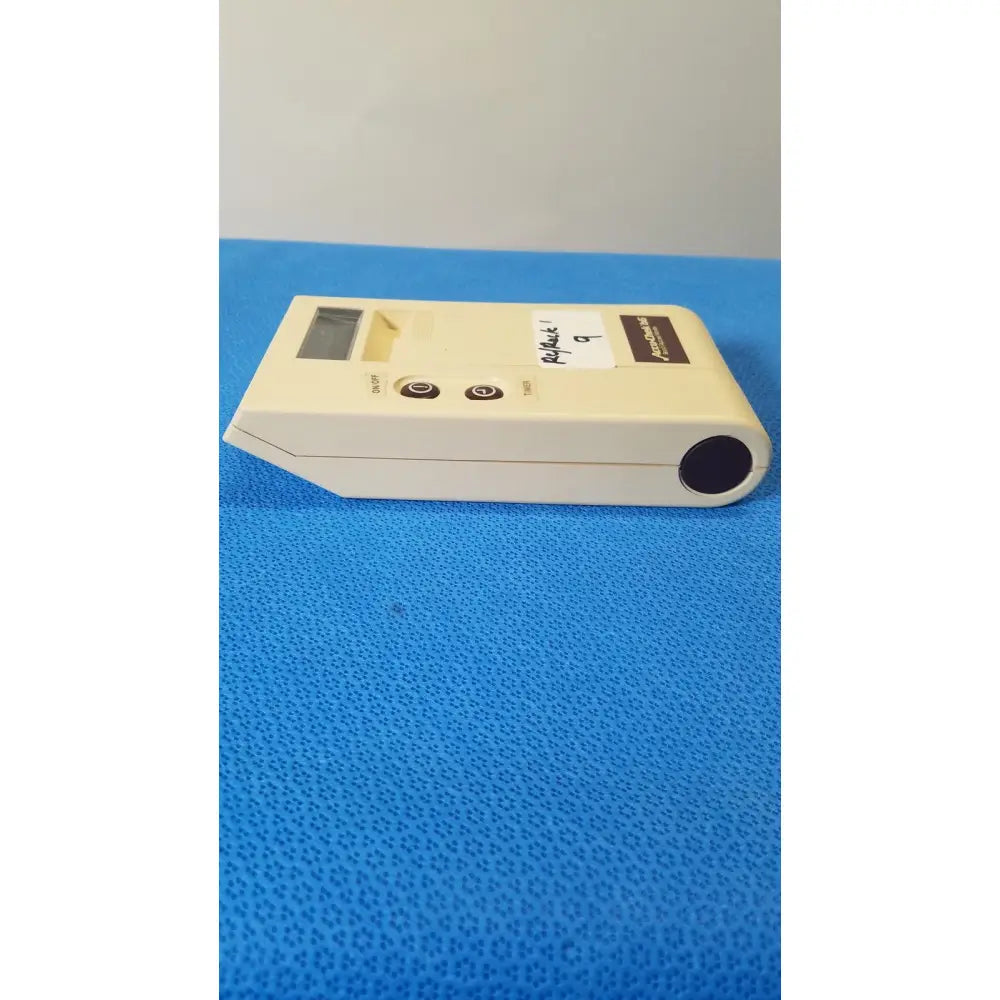Cream-colored bio-dynamics accu-chek bG blood glucose monitor with digital display, on/off test buttons, and black lens