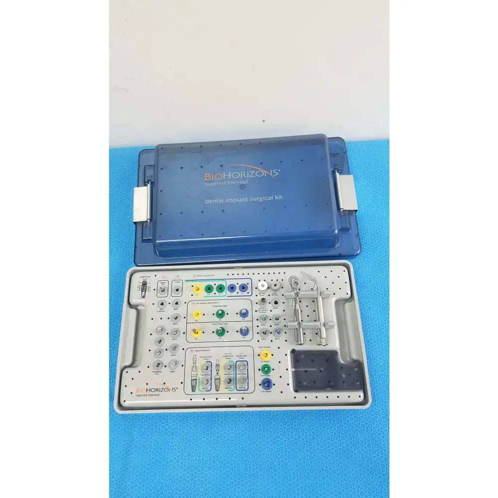 Blue Bio Horizons tapered internal dental implant surgical kit with organized trays holding metallic tools and colored components