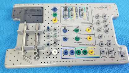 Gray plastic surgical instrument tray with organized compartments holding blue green yellow and silver tools for tapered internal dental implant surgery kit