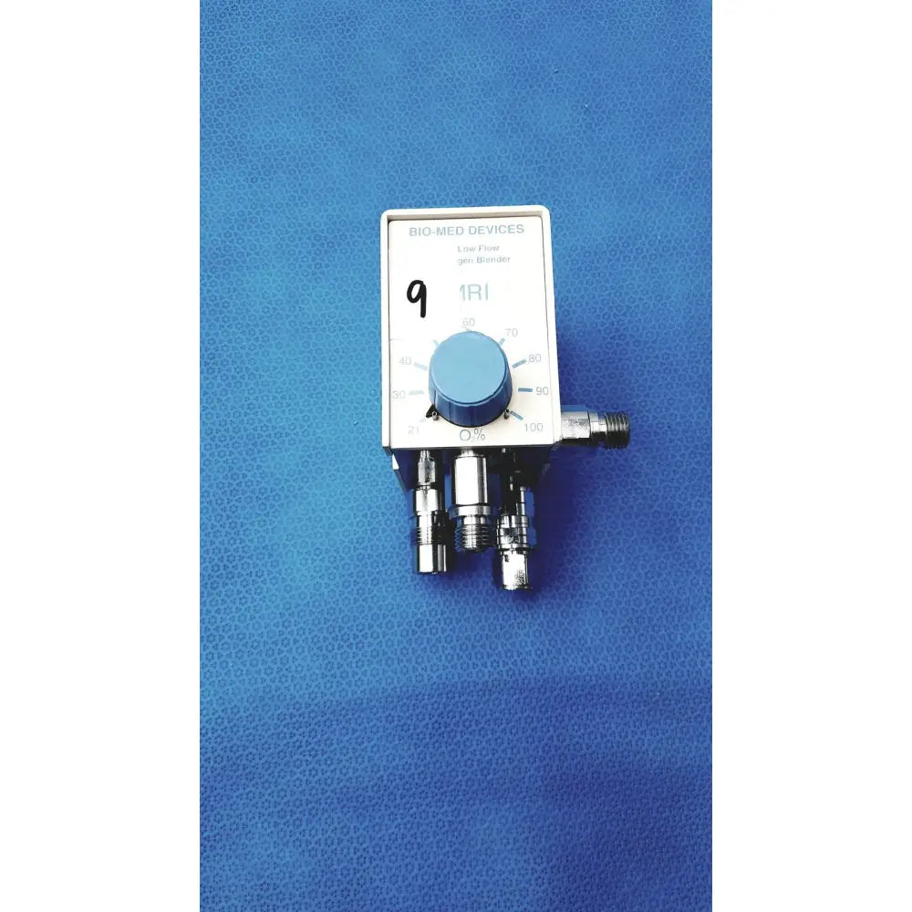 White rectangular medical air oxygen blender with blue dial and metallic ports by bio-med devices for respiratory gas mixing