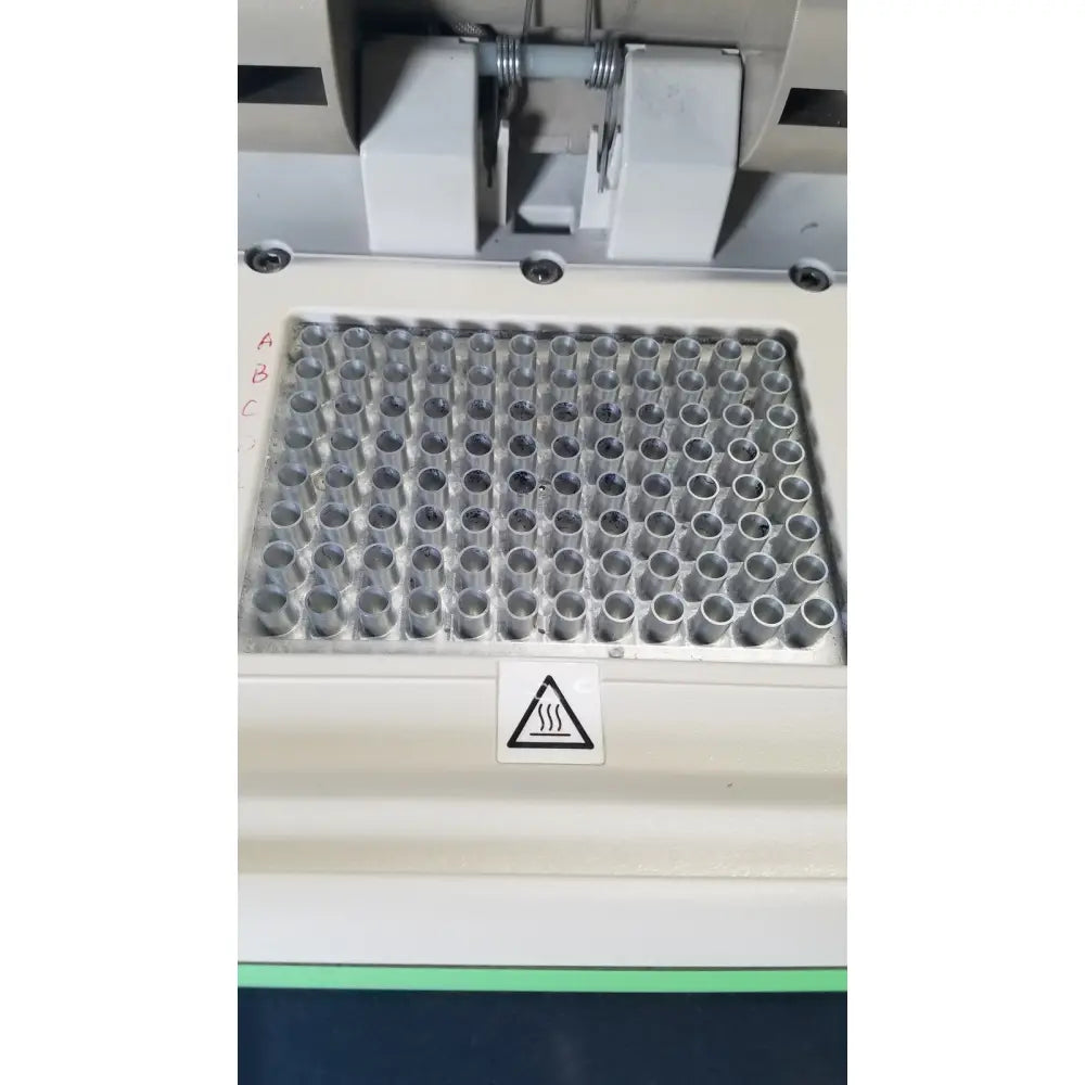 A white plastic microplate tray with 96 wells holding clear tubes in a bio-rad mycycler thermal cycler 580br