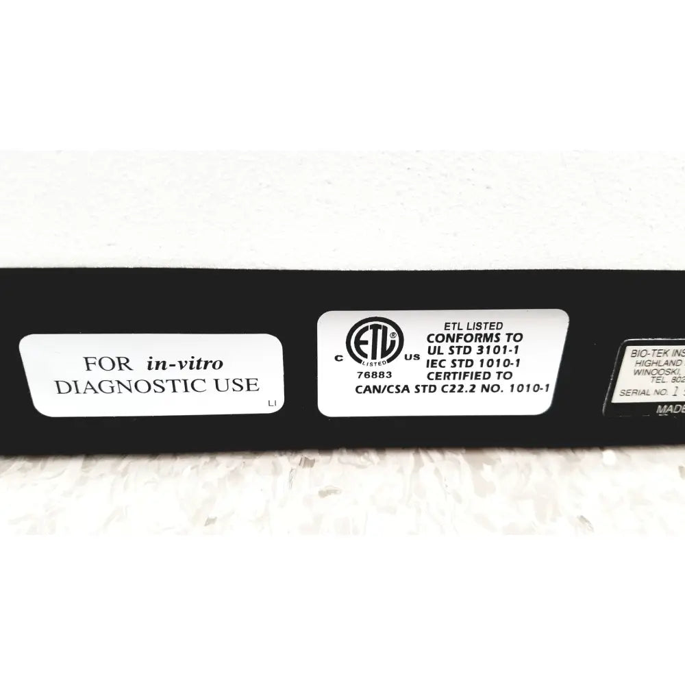 Black rectangular instruments elx800 universal microplate reader showing white certification labels on its back side