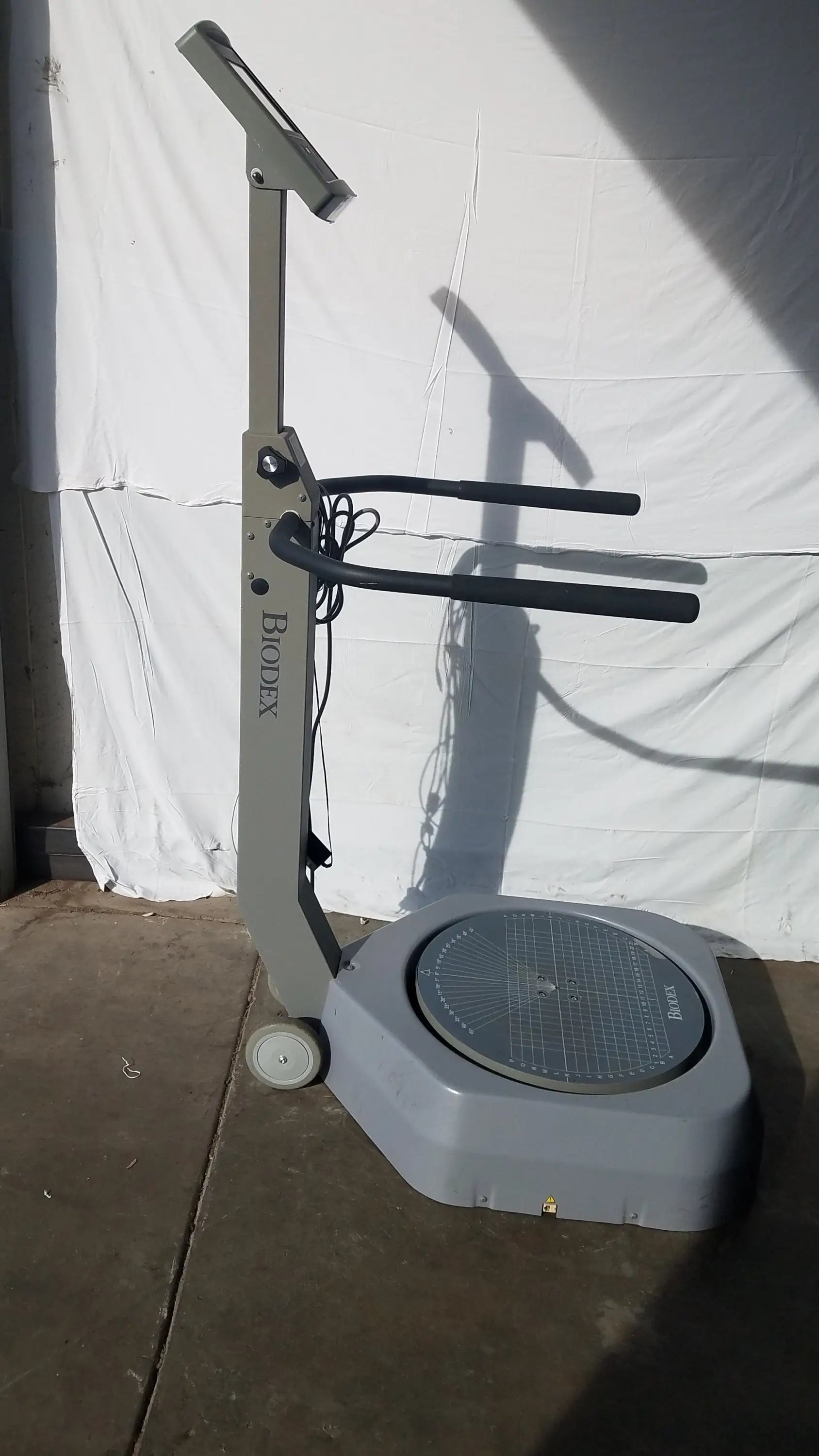 Gray biodex 950-300 balance system sd exercise machine with circular platform and adjustable handlebars for balance assessment serial number 0705499