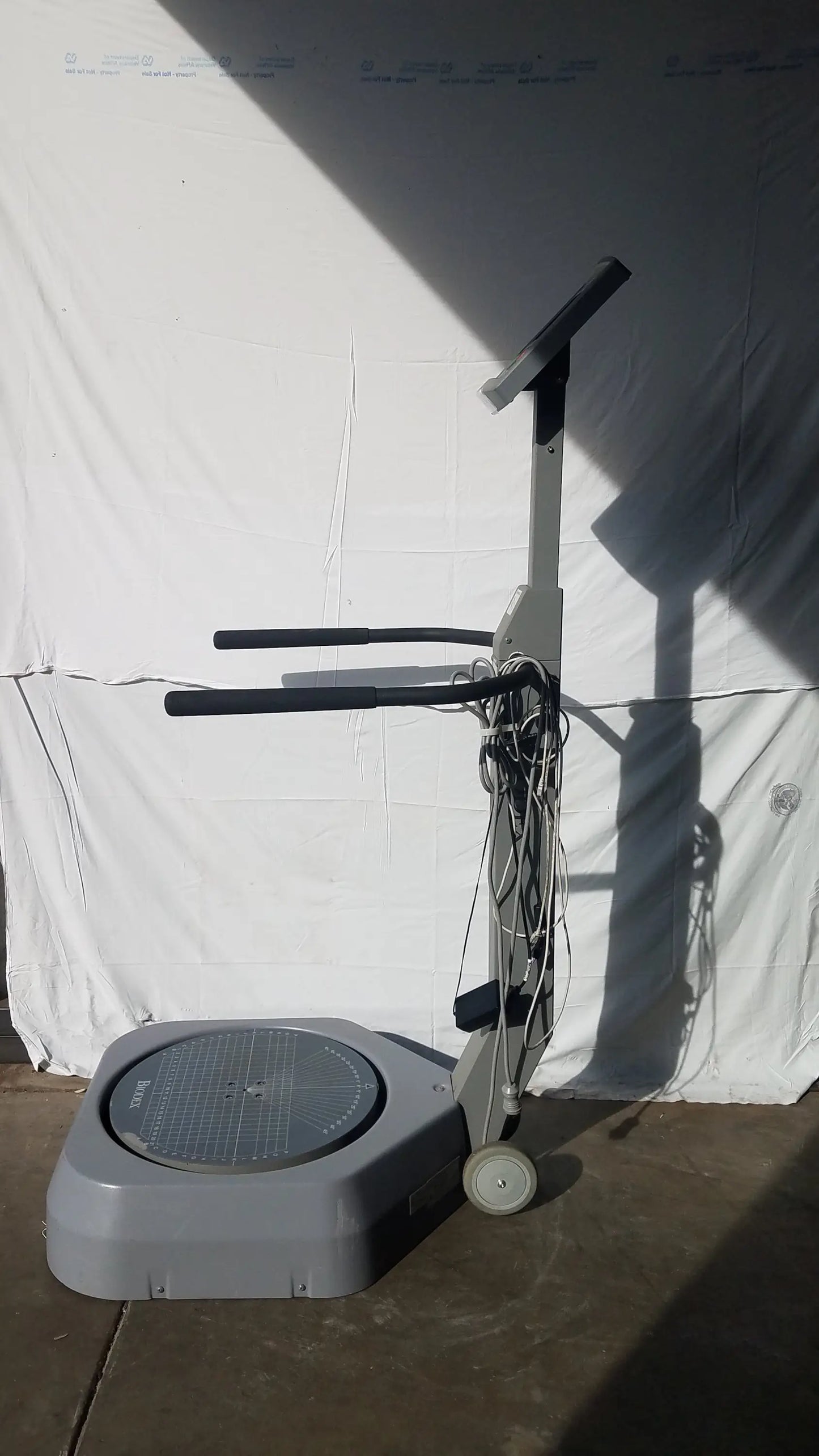 Gray biodex 950-300 balance system with circular platform black handlebars wheels for balance assessment serial number 0705499
