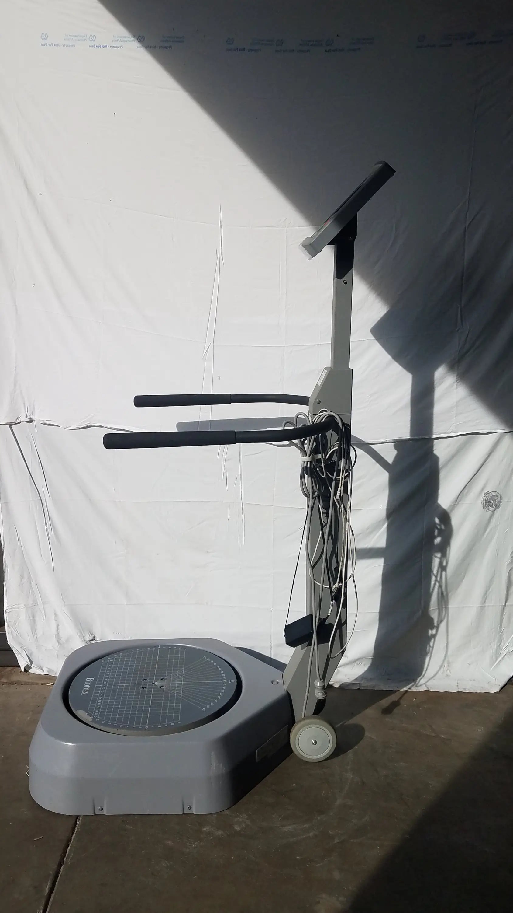 Gray biodex 950-300 balance system with circular platform black handlebars wheels for balance assessment serial number 0705499
