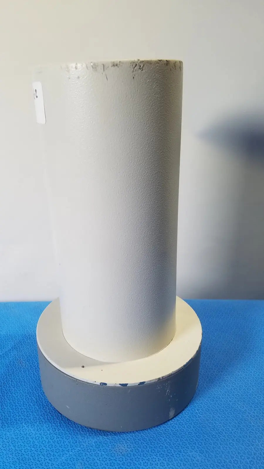 White cylindrical pipe with textured surface mounted on gray base for reuse medical in biodex well counter 187-602