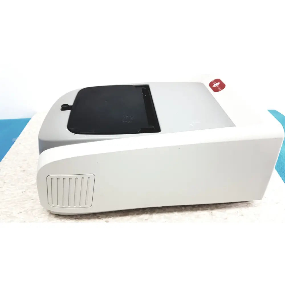 Gray plastic biofire diagnostics filmarray 2.0 pcr system with black lid and red circular sticker on top