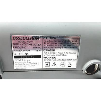 Gray plastic label with black and pink text displaying biomet 3i osseocision ne111 advanced surgical drill system model number