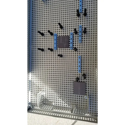 Gray perforated metal grid with black and blue plastic connectors in summit medical ua2438 instrument sterilization tray