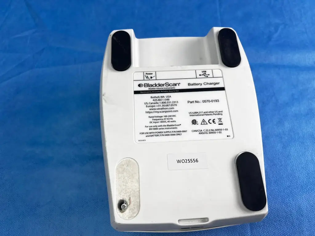 White plastic bladderscan battery charger with black rubber feet and label for reuse medical device 0570-0193