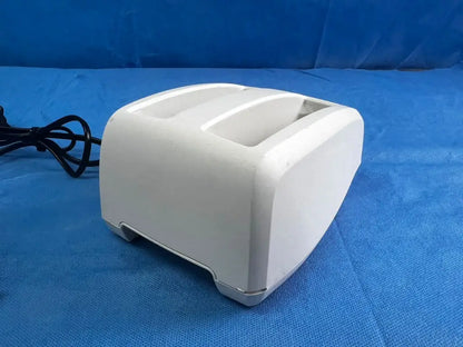 White plastic two-slot toaster with black power cord for bladderscan battery charger reuse medical applications