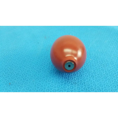 A glossy orange blood pressure inflation bulb pump with a metallic blue valve hole at its base for pressure inflation