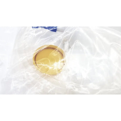 A translucent yellow circular lid inside clear plastic wrap for boston scientific m0068402980 stone catcher