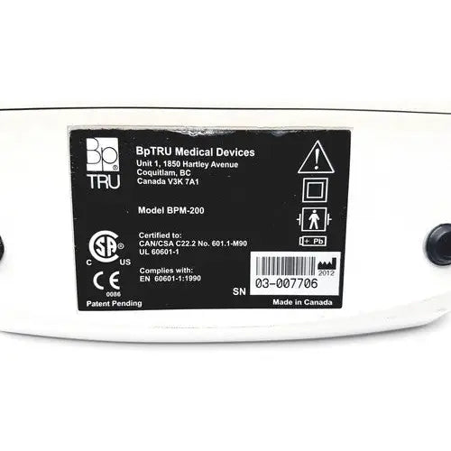 White bp tru bpm-200 automatic blood pressure monitor showing black label with certification and serial number details