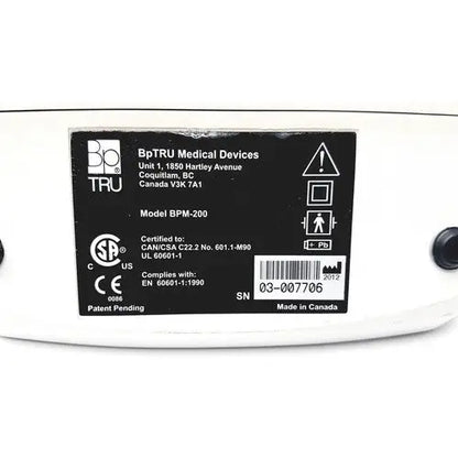 White bp tru bpm-200 automatic blood pressure monitor showing black label with certification and serial number details