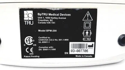 White bp tru bpm-200 automatic blood pressure monitor showing black label with certification and serial number details