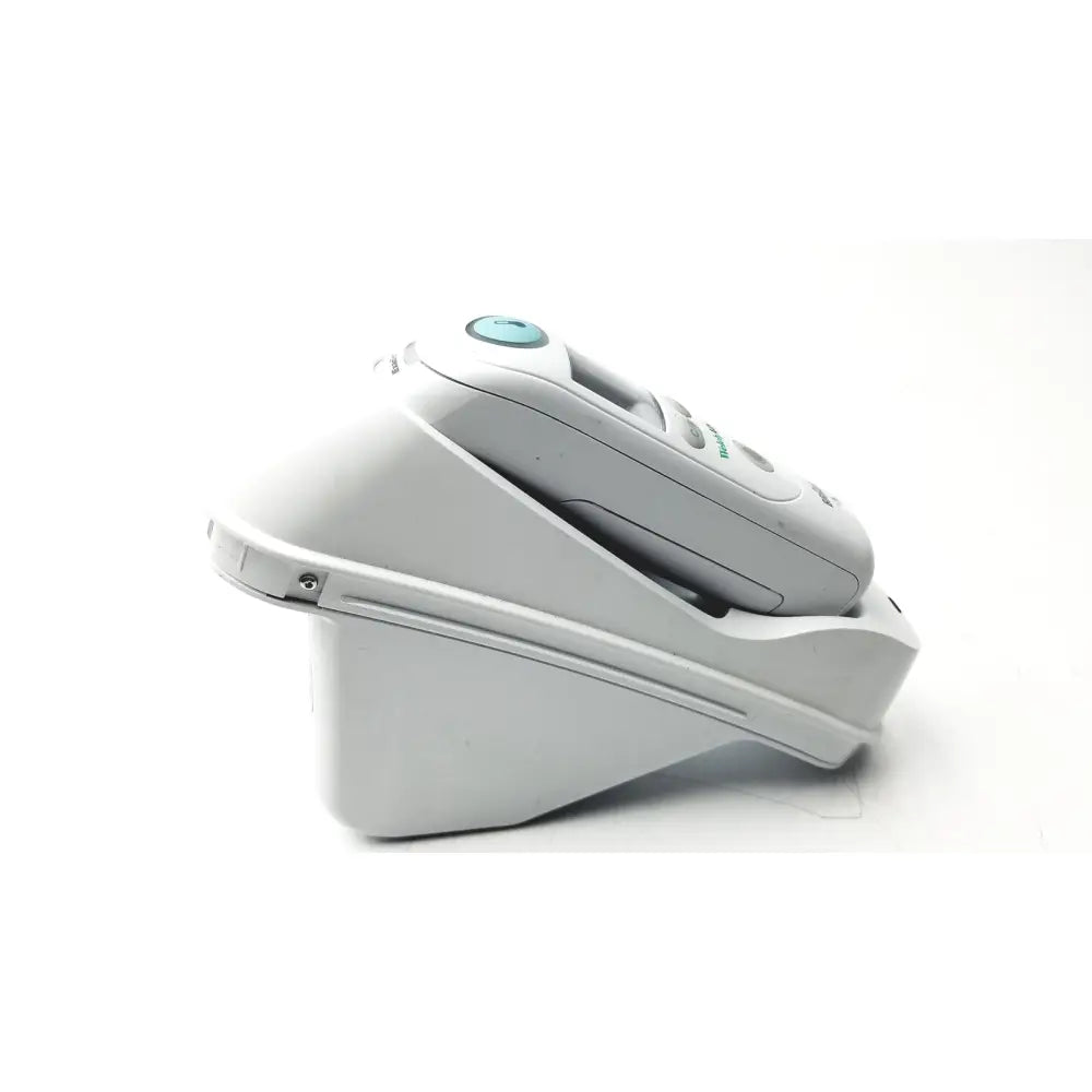 White philips sonicare electric toothbrush resting in its charging base contrasting with braun thermoscan pro ear thermometer ref