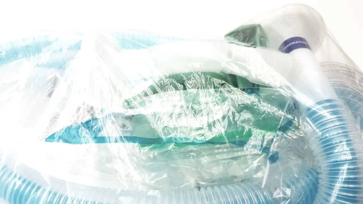 Green and white medical breathing circuit with breathing bag coaxial and blue corrugated tubing in clear plastic packaging