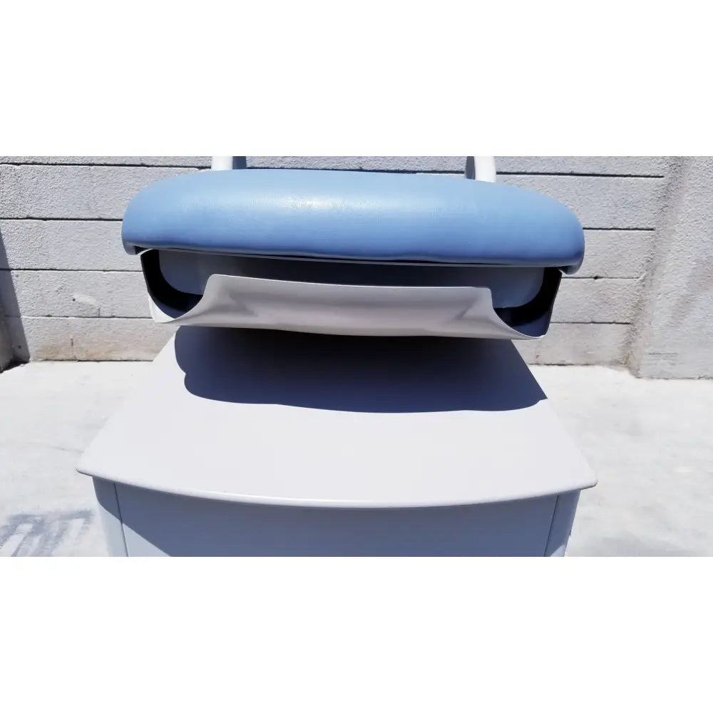 Light blue padded seat with white base and black interior on brewer access high-low exam table for medical use