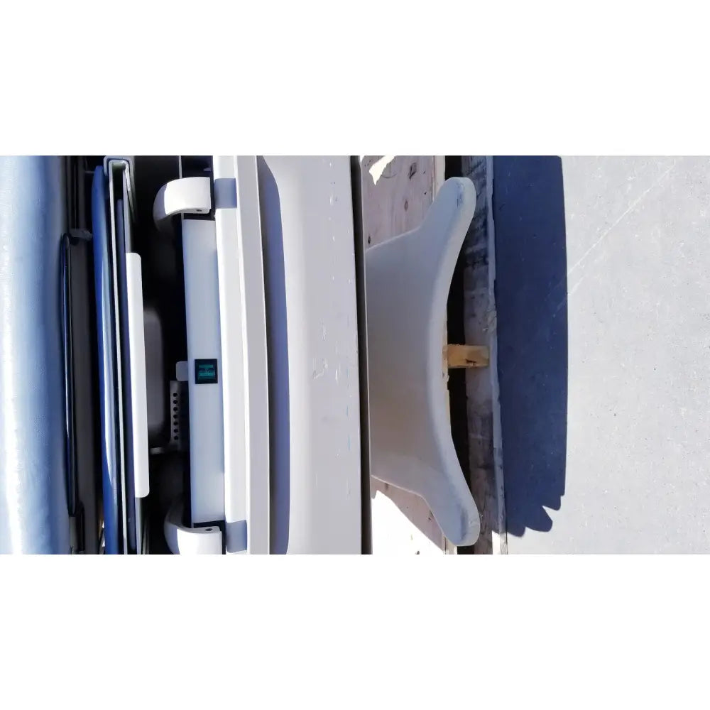 White plastic car seat with curved backrest and integrated head support on brewer access high-low exam table