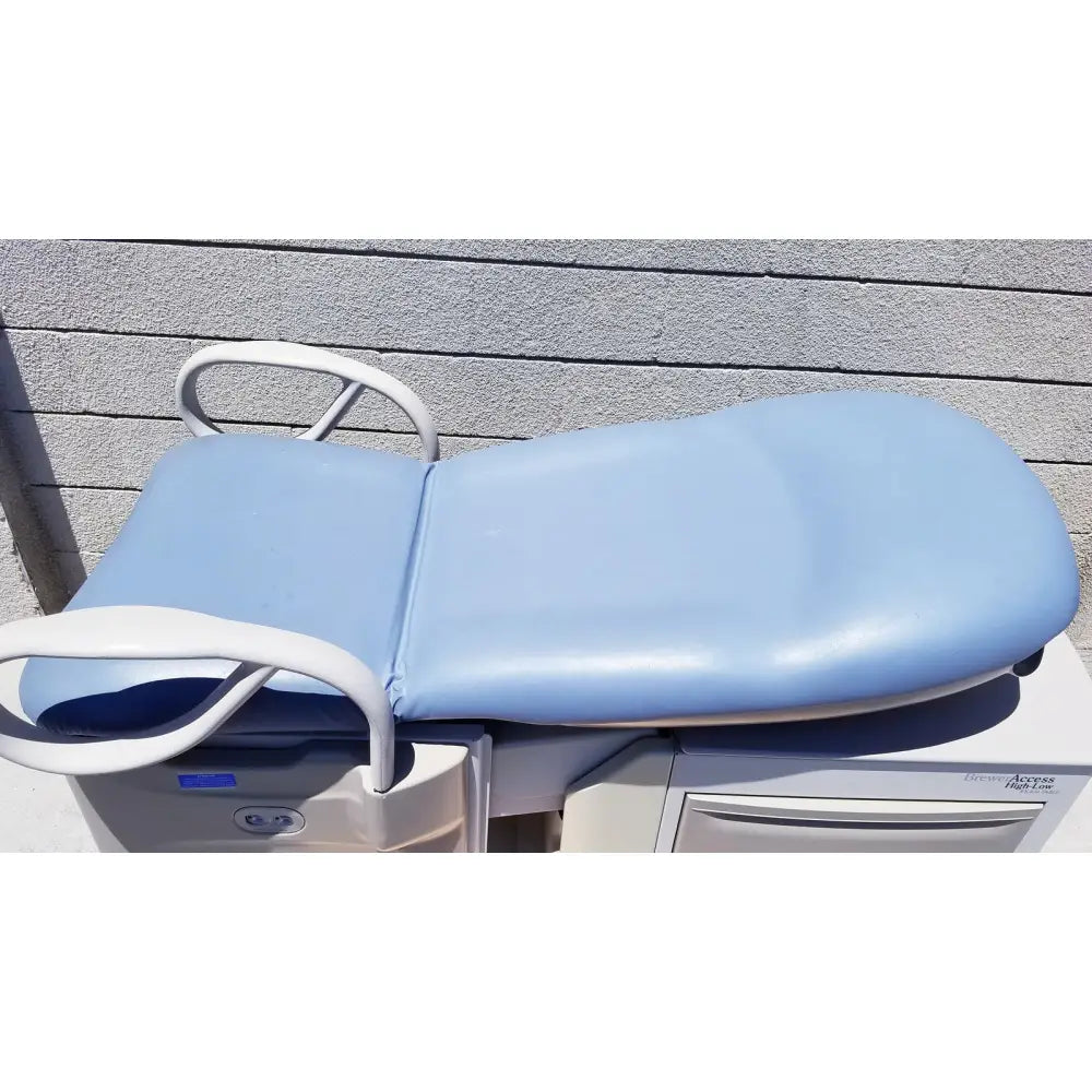 Brewer Access high-low exam table with light blue padded surface white metal frame and curved armrests