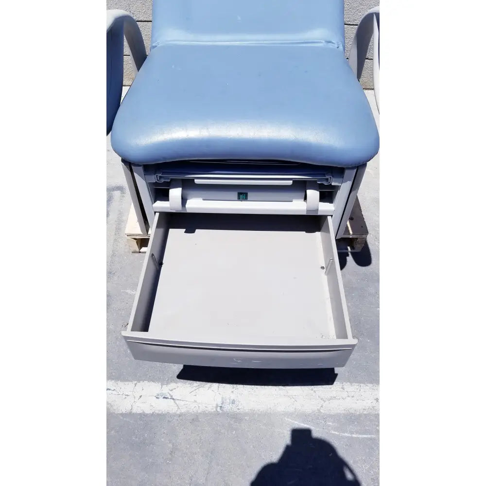 Light blue padded brewer access high-low exam table with gray metal frame and open storage drawer beneath