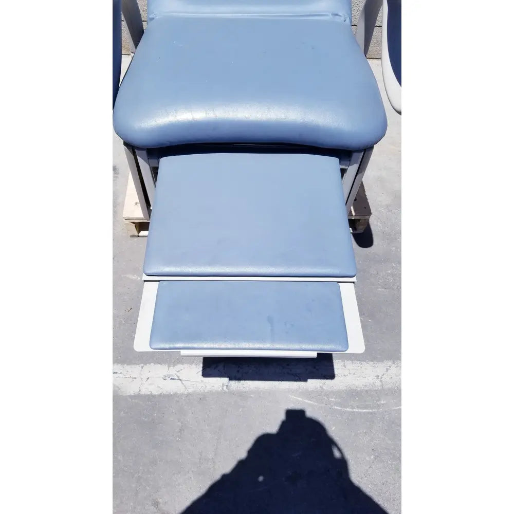 Light blue padded brewer access high-low exam table with adjustable footrests and metal frame for medical use