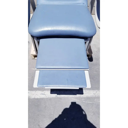 Light blue padded brewer access high-low exam table with adjustable footrests and metal frame for medical use