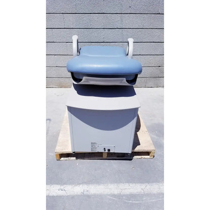 Brewer Access high-low exam table with light blue padded top, white armrests, gray base on wooden pallet