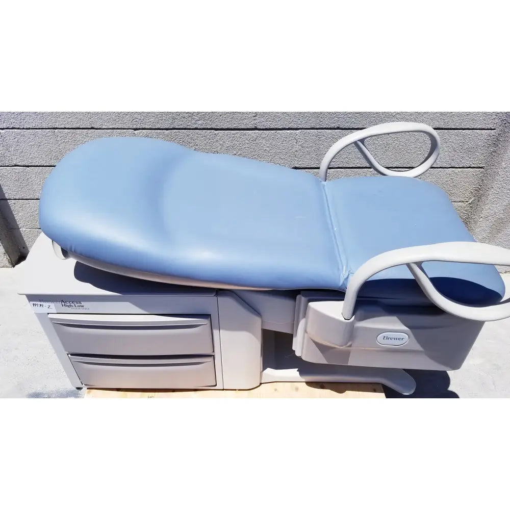 Brewer Access high-low exam table with light blue padded top, white metal frame, and built-in storage drawers