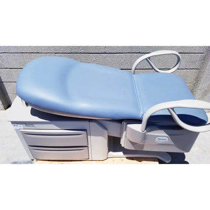 Brewer Access high-low exam table with light blue padded top, white metal frame, and built-in storage drawers