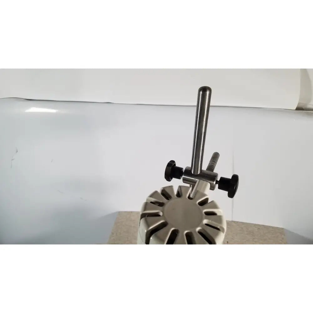 Silver metallic brinkmann kinematica homogenizer mixer with black adjustment knobs and circular base with radial slots