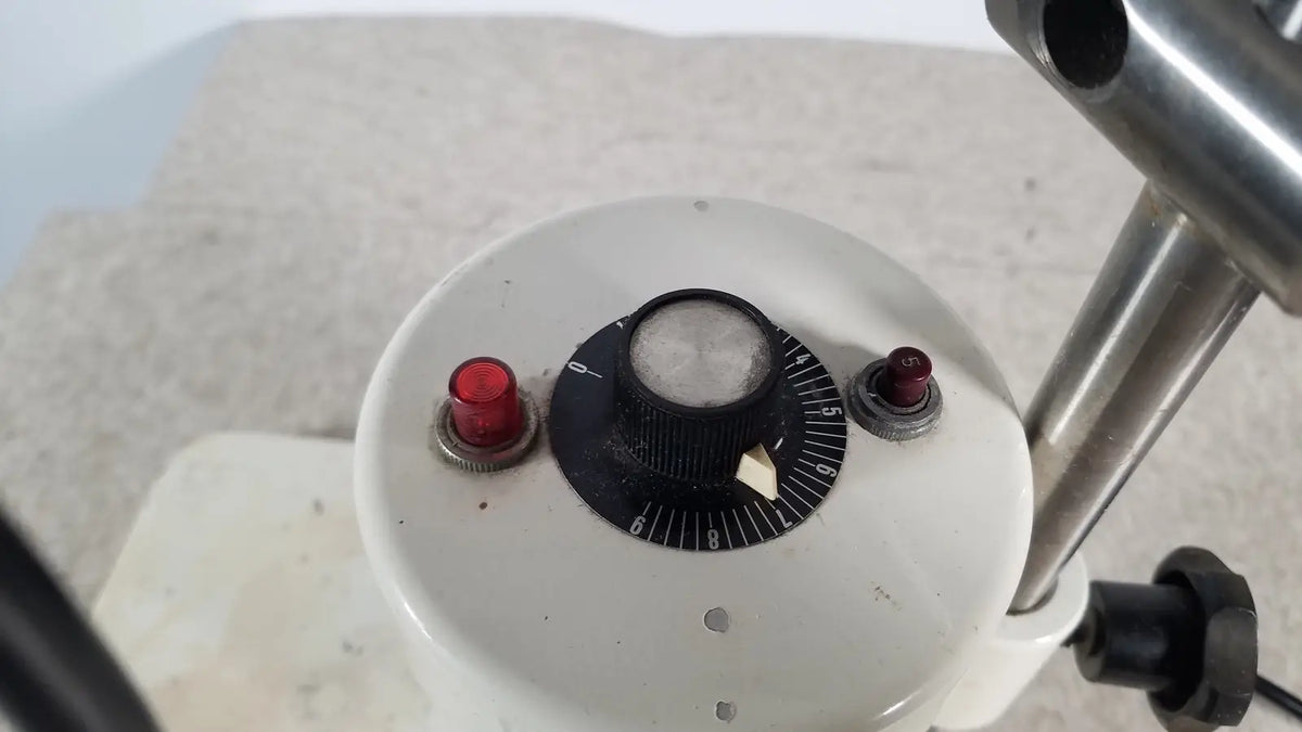 White circular dial with black numbered scale and central knob flanked by red push buttons on brinkmann kinematica homogenizer mixer