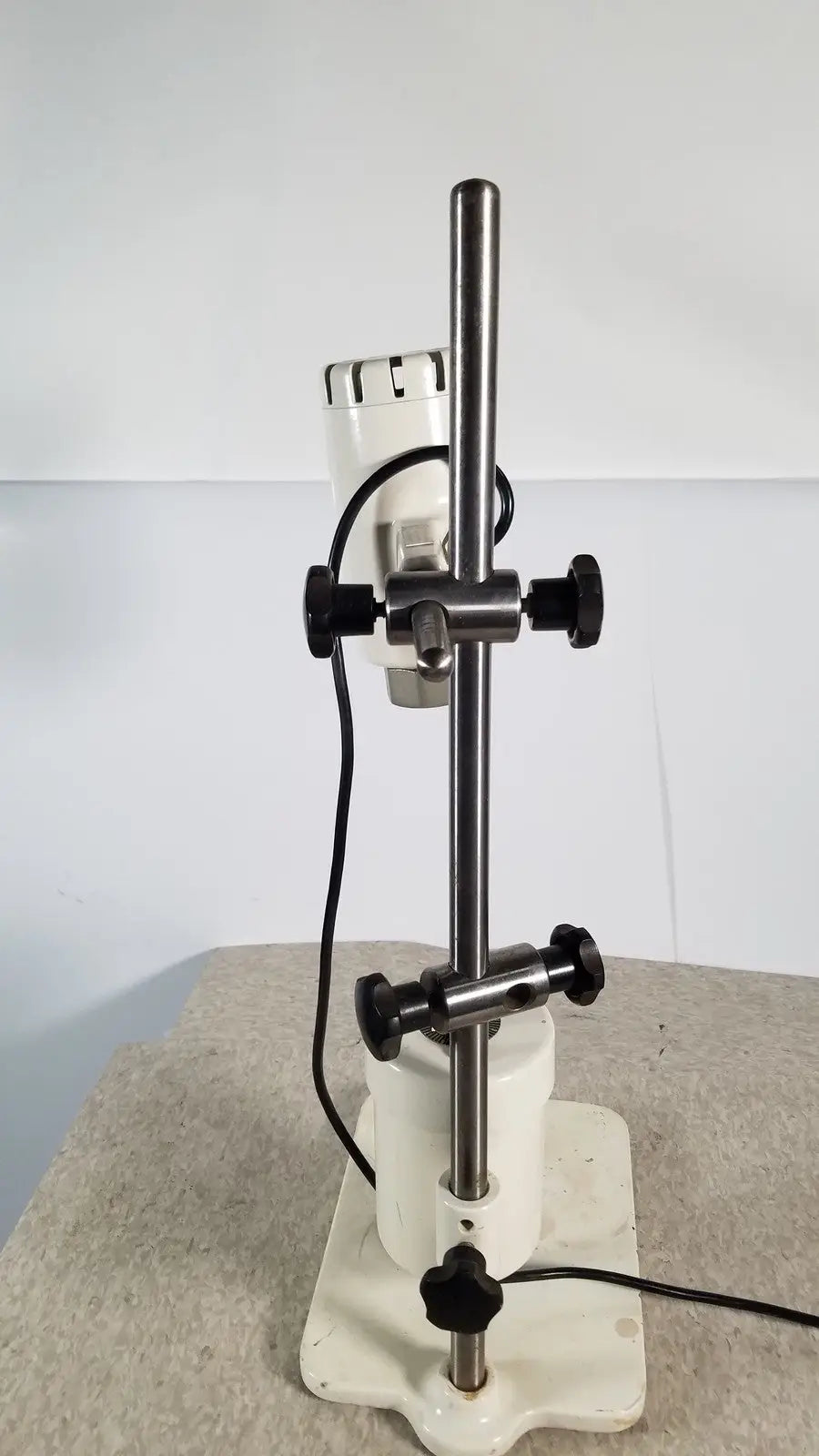 White laboratory stirrer with metallic rod and black knobs used in brinkmann kinematica homogenizer mixer device