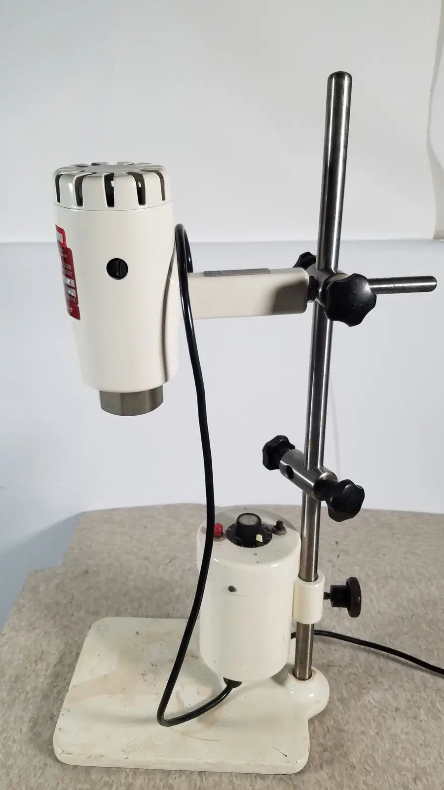 White brinkmann kinematica homogenizer mixer with metallic top and black knobs mounted on adjustable stand