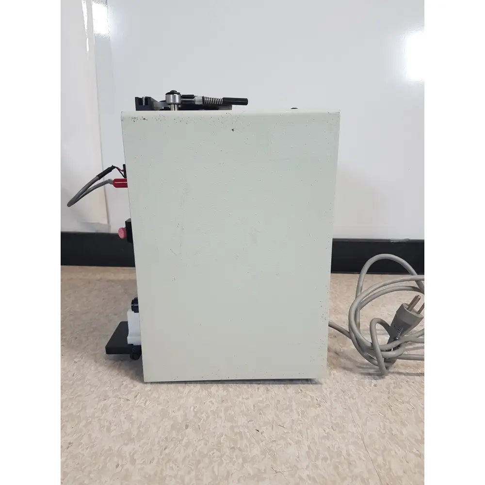 Light gray rectangular buchler instruments auto densi-flow ii c density gradient fractionator with black components and coiled power cord
