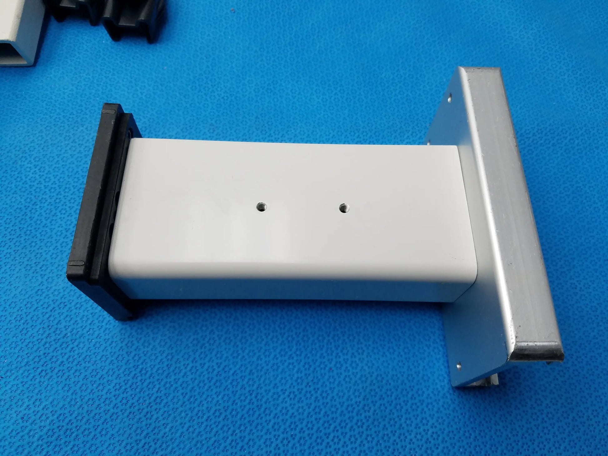 White rectangular plastic housing with black and silver metal brackets for burton medical outpatient ii examination light wall mount assembly