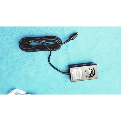 Black usb cable with coiled design and rectangular power adapter with circular dial for burton ultraviolet examining light