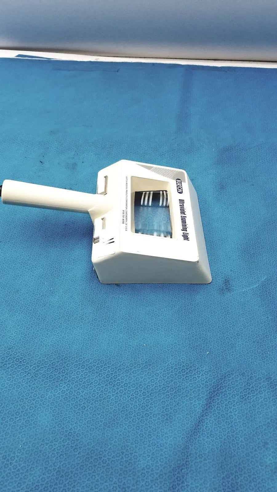 White plastic dustpan with handle and integrated brush head labeled advanced dusting tool for burton ultraviolet examining light use