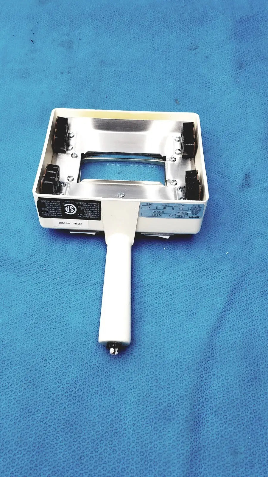 White-handled handheld magnifier with metallic silver frame and black clamps for burton ultraviolet examining light use