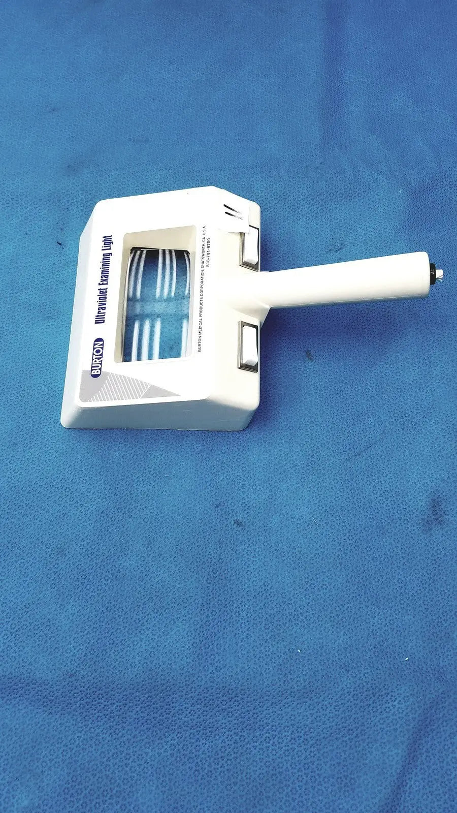White plastic burton ultraviolet examining light with blue illuminated strips visible through transparent window