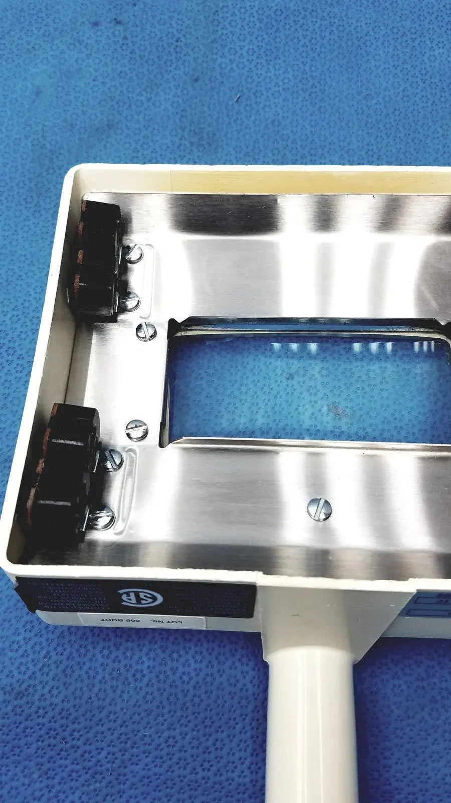 Silver metallic rectangular housing with black connectors and white handle of burton ultraviolet examining light 31601