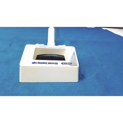 White plastic Burton ultraviolet examining light with rectangular base and vertical handle for medical use