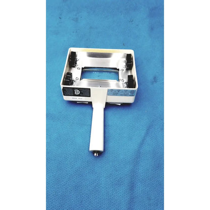 White-handled handheld magnifier with metallic silver frame and black clamps for burton ultraviolet examining light use